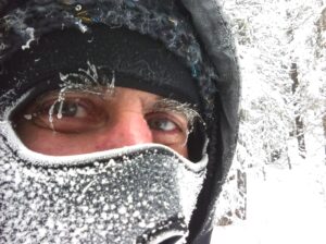 Photo of face covered in frost, only eyes visible.