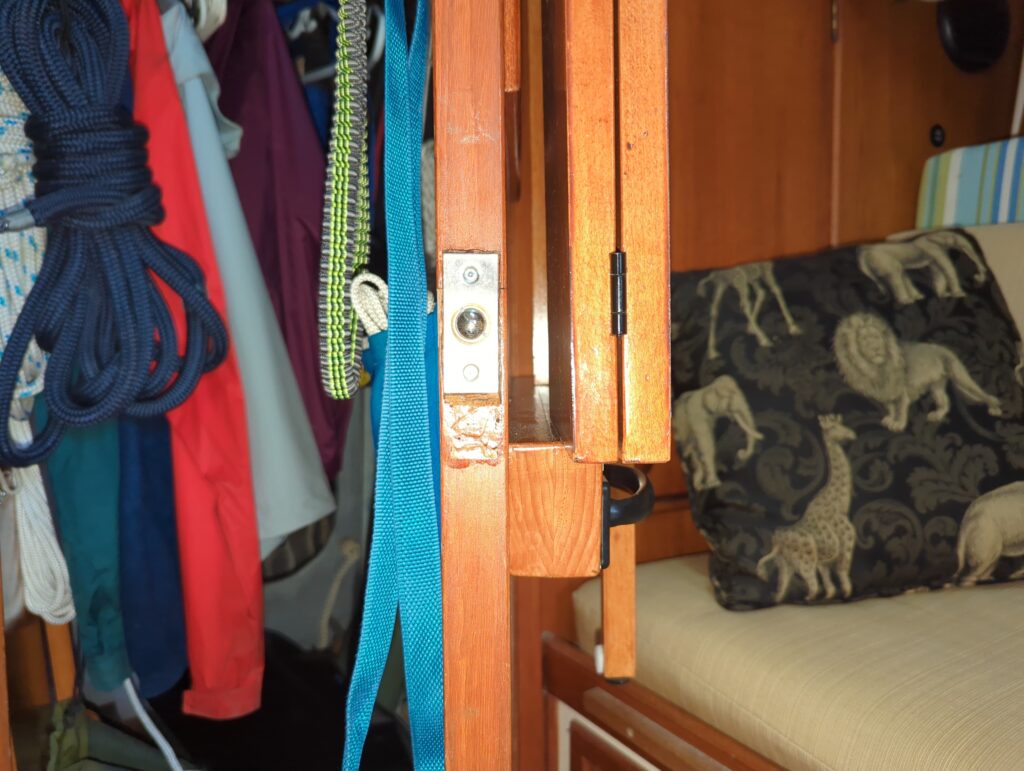 Side view of table folded up with gap between it and louvres, plus ball catch on door and fixed handle